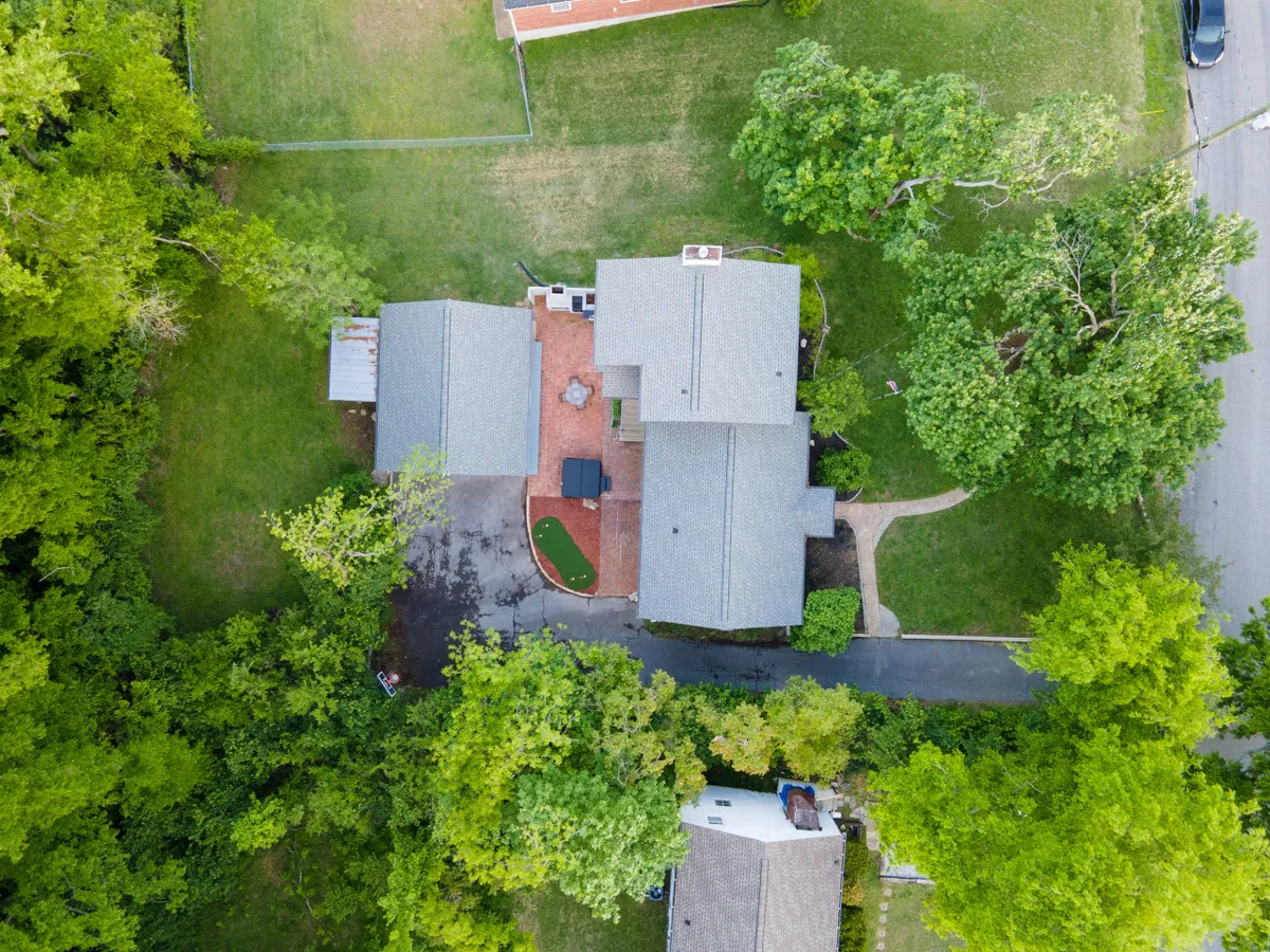 The image shows the property’s main house structure with a welcoming patio area and abundant surrounding greenery, capturing the overall exterior ambiance and sense of seclusion, while hinting at the expansive space available for group activities.